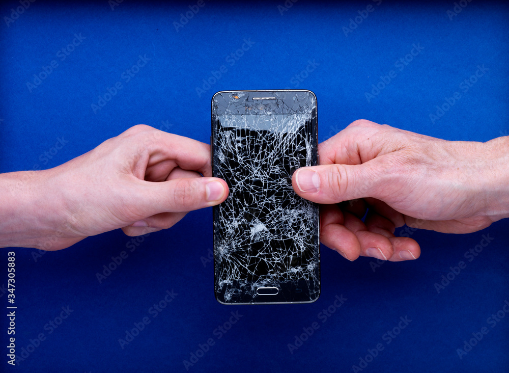 Smartphone écran cassé brisé tenu par deux mains avec réparer Stock — free download