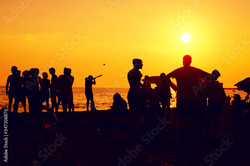 Beach Party.Silhouettes of teenagers at sunset in the evening.Bachelorette party on the coast.cheerful teenagers gathering on the beach at dusk.Silhouettes of teenagers at sunset on the beach.