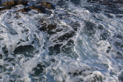 Mediterranean sea waves splashing at the rocks with foam in Chania, Crete Island, Greece.