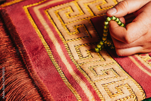 Islamic Holly Book and praying beads on mat prayer oriental style photo