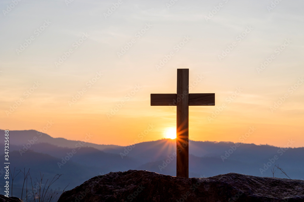 Silhouettes of crucifix symbol with bright sunbeam on the colorful sky background Silhouettes of crucifix symbol with bright sunbeam on the colorful sky background