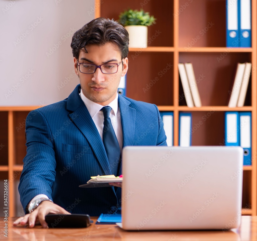 Fototapeta premium Young handsome businessman working in the office
