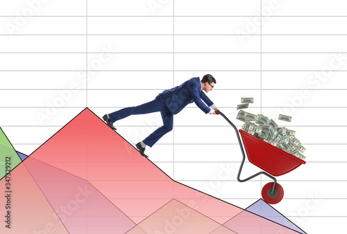 Businessman pushing money wheelbarrow down the chart
