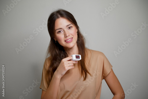 portrait of a young woman with pulse oximeter