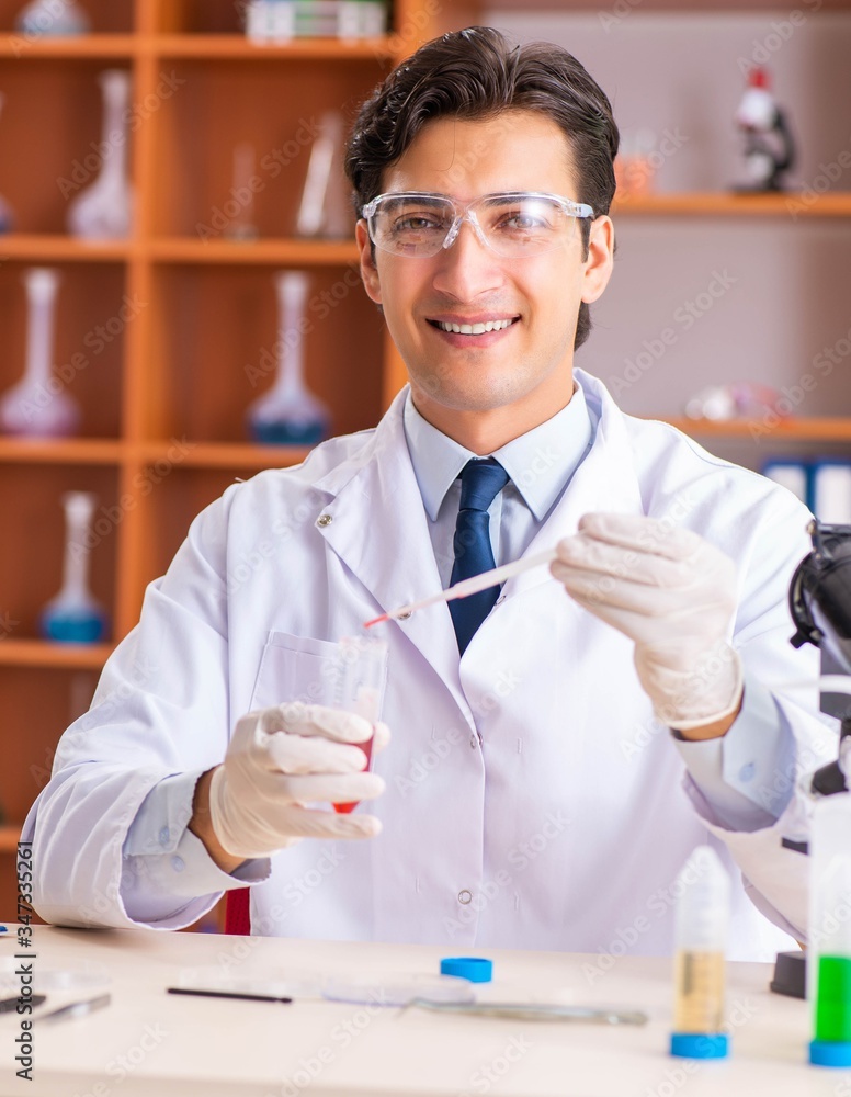 Young handsome biochemist working in the lab