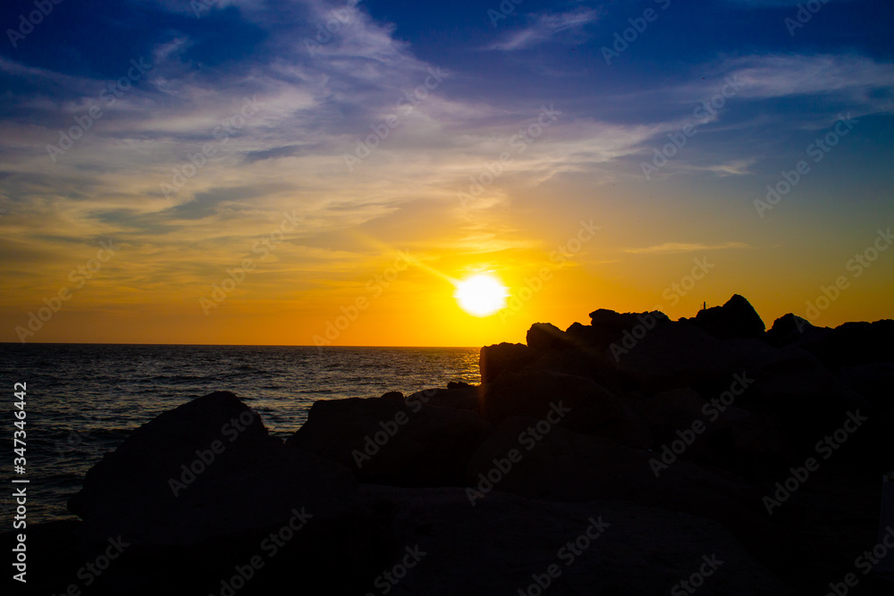 Puesta de sol en la playa con rocas