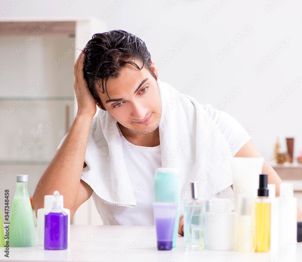 Young handsome man in the bathroom in hygiene concept Young handsome man in the bathroom in hygiene concept