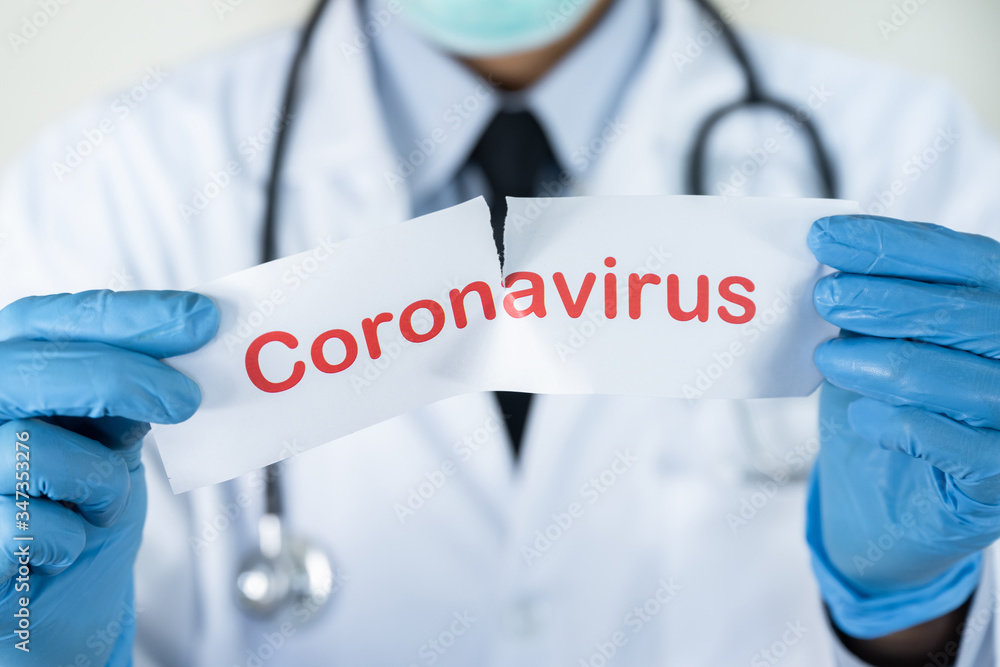 Doctor with a stethoscope hand holding red text on white paper with the word coronavirus, stop covid-19 concept Doctor with a stethoscope hand holding red text on white paper with the word coronavirus, stop covid-19 concept