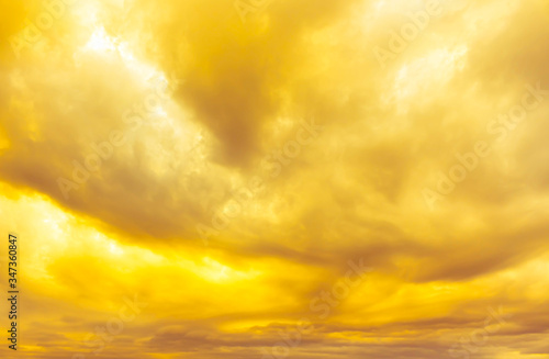 abstract yellow and orange blurred clouds in gold sky