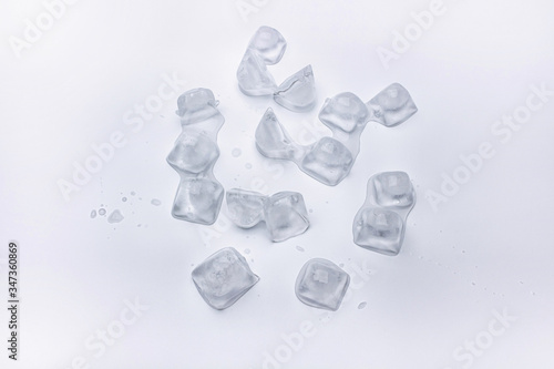 Ice cube are melting on white background with water drop