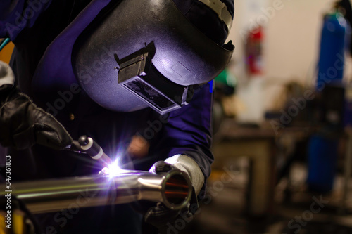 Metal workers use manual labor. Skilled welder. Factory workers making OT. Welder is welding the steel in the factory. welder Industrial automotive part in factory. © niwat