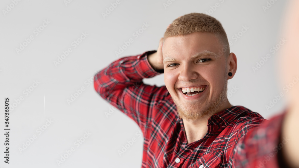 A cheerful, positive man laughs at the camera and photographs himself. A cheerful, positive man laughs at the camera and photographs himself.