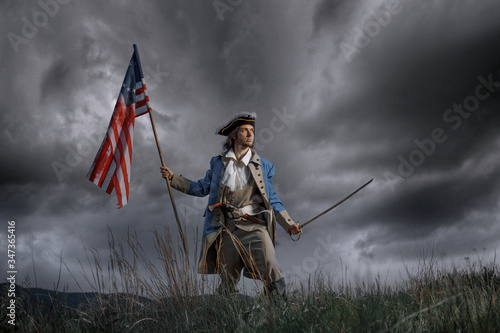 Man in United States War of Independence soldier costume with flag posing in forest. 4th July independence day of USA concept photo photo