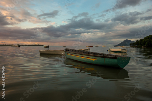 fabulous view of the sunset in Mauritius. Fishing boats on the background of mountains and colorful clouds