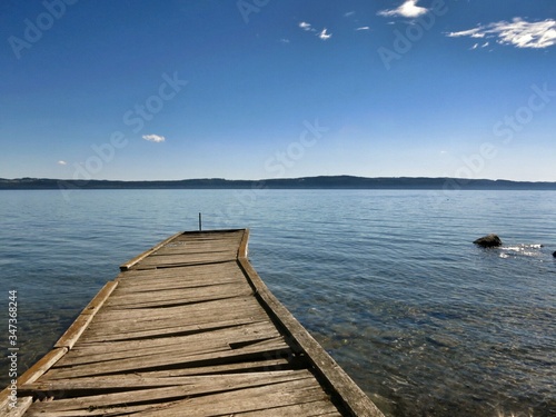 Wooden Jetty Leading To Calm Blue Sea
