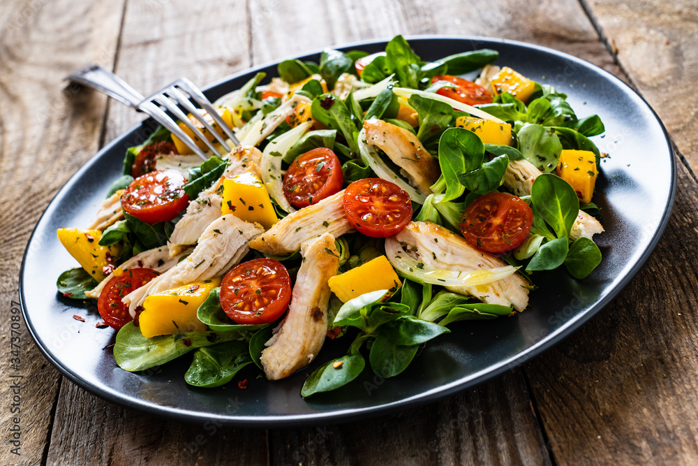 Caesar salad - fried chicken breast and vegetables on wooden table
Caesar salad - fried chicken breast and vegetables on wooden table