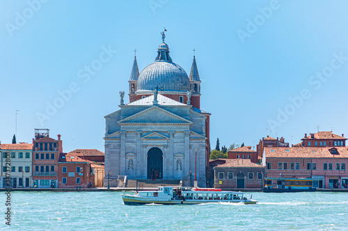 Church of Ile Redentore on the island of Judecca, washed by emerald green water oh a canal (Canale della Giudecca). Venice, Italy, Europe.