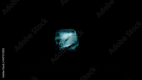 Close-up of melting blue ice cubes on black background
