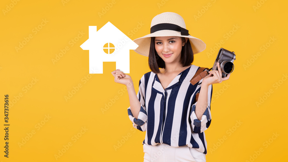 Young Asian woman holding paper home cutout on light blue banner background for real estate concept.copy space isolated on pink banner background. Young Asian woman holding paper home cutout on light blue banner background for real estate concept.copy space isolated on pink banner background.