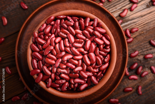 Top view a bowl of raw red beans on a wooden table