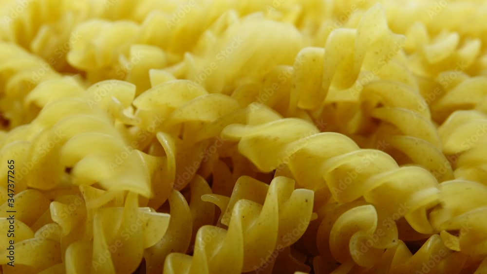 4K Uncooked pasta Rigatoni and Fusilli on food background. Cooking concept. 4K Uncooked pasta Rigatoni and Fusilli on food background. Cooking concept.