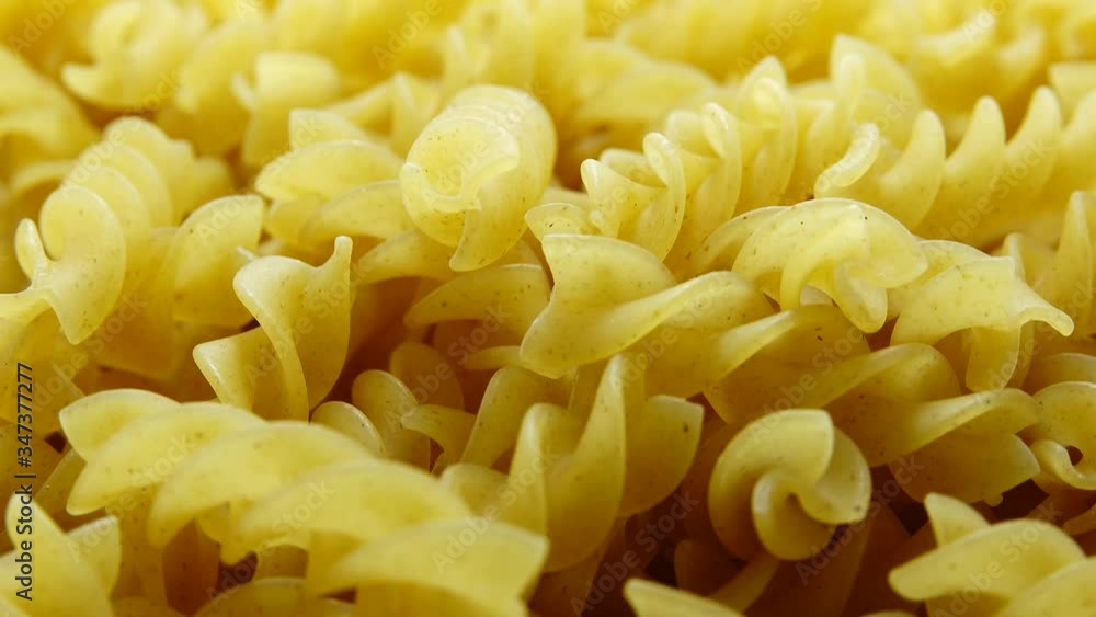 4K Uncooked pasta Rigatoni and Fusilli on food background. Cooking concept. 4K Uncooked pasta Rigatoni and Fusilli on food background. Cooking concept.
