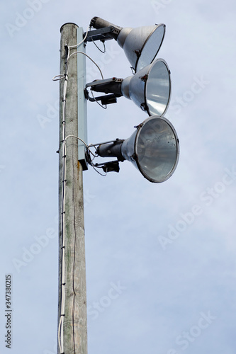 three strong spotlights on a wooden post © Peter