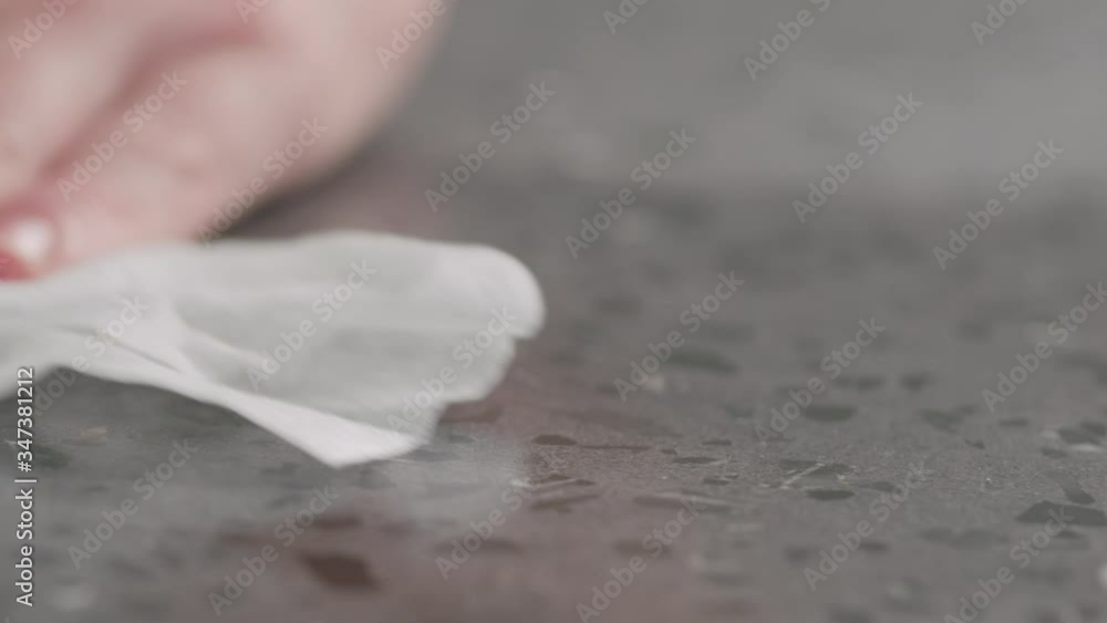 Slow motion spraying sanitizer on concrete countertop surface and wipe it macro shot Slow motion spraying sanitizer on concrete countertop surface and wipe it macro shot