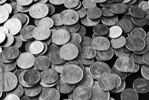 American cents on an old black wooden surface close-up. Monochrome money background