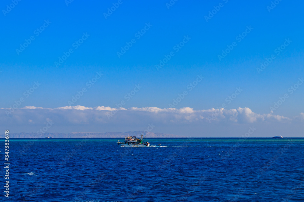 Fishing trawler sails at Red sea in Hurghada, Egypt Fishing trawler sails at Red sea in Hurghada, Egypt