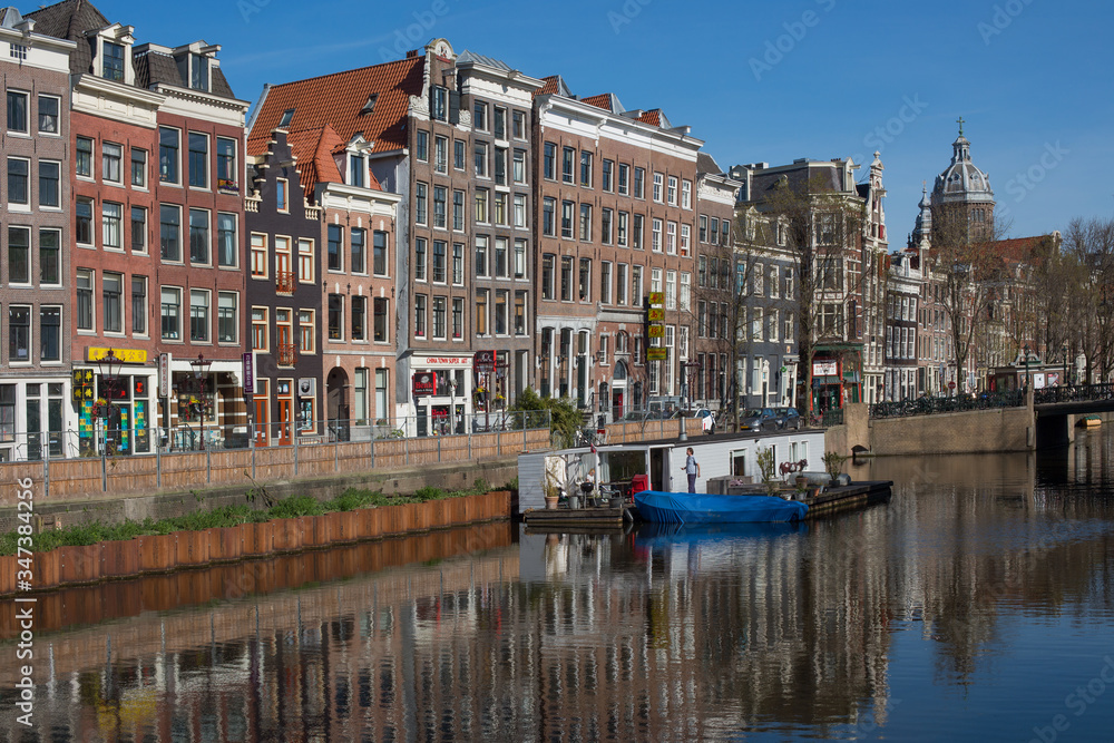 April 2020 - Amsterdam, The Netherlands - Romantic view of Amsterdam city centre canals and boats on Spring time 