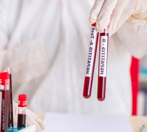 Young handsome lab assistant testing blood samples in hospital