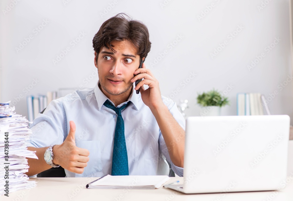 Overloaded busy employee with too much work and paperwork Overloaded busy employee with too much work and paperwork