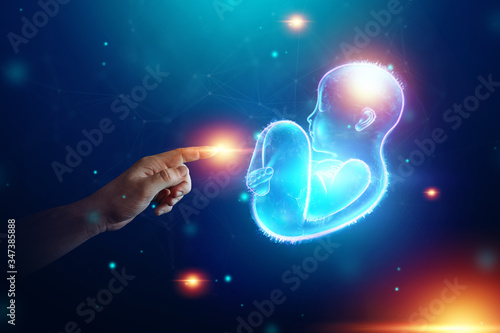 Infant, a child in a fetal position, an embryo, a hologram on a dark background. Pregnancy concept, artificial insemination, copy space.
