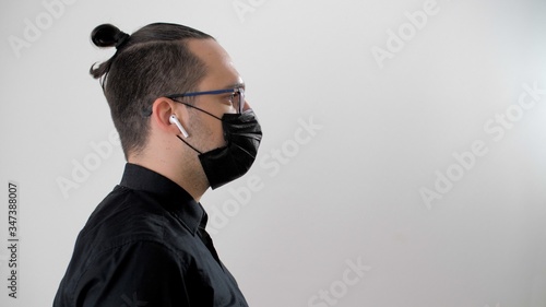 Portrait of a young man in a black protective medical mask to prevent the spread of the virus during coronavirus or covid-19. Health care and medical concept. People, medicine, healthcare. photo