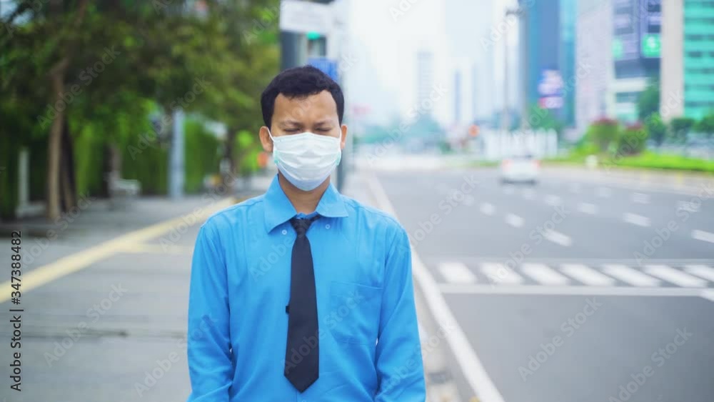 Businessman wears mask and standing on sidewalk Businessman wears mask and standing on sidewalk