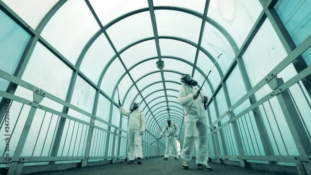 People use sprayers to disinfect walkway. People use sprayers to disinfect walkway.