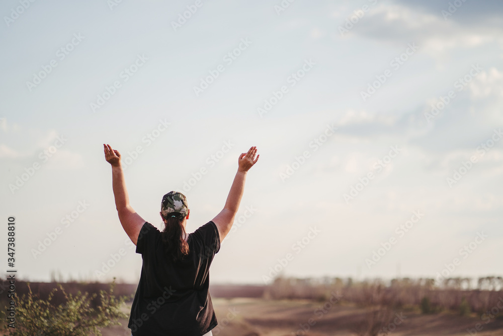 Life goals and achievement. Happy woman standing in nature. Female runner raising arms expressing positivity and success. Life goals and achievement. Happy woman standing in nature. Female runner raising arms expressing positivity and success.