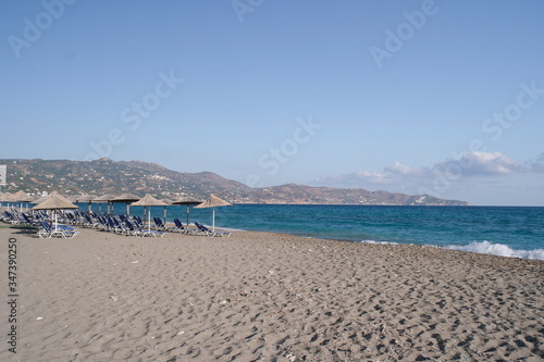 straw beach umbrella on a sandy beach near the Mediterranean sea