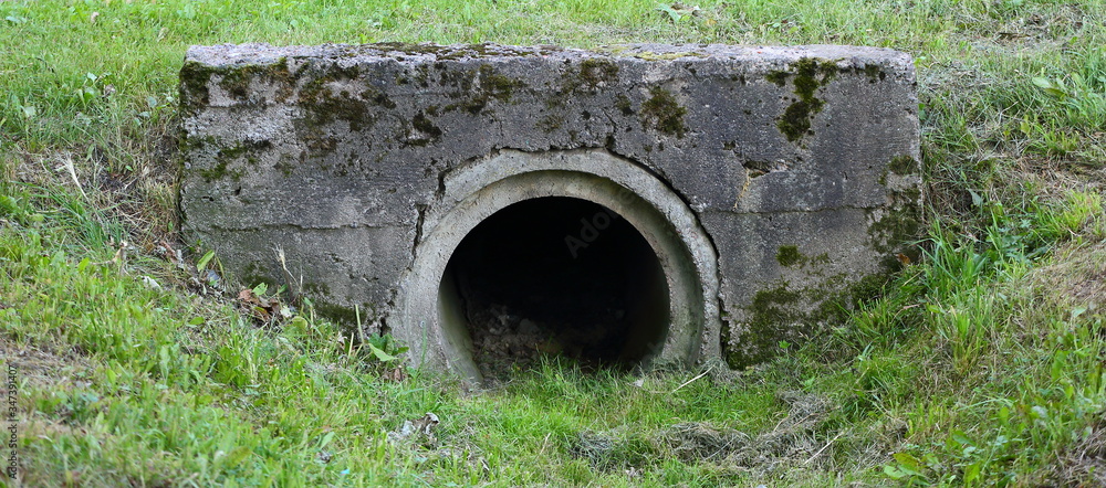 Drainage pipe connecting the ditch under the bridge in the Park