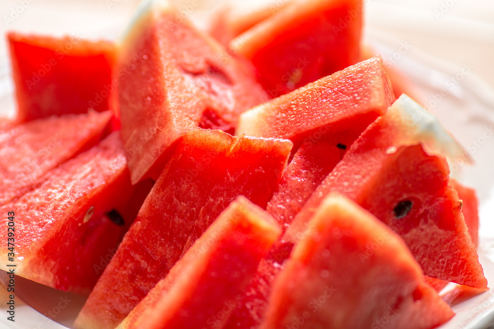 The background of the red flesh watermelon, placed in a ready-to-eat white plate, is a fruit that has a sweet taste and is an alternative health menu. The background of the red flesh watermelon, placed in a ready-to-eat white plate, is a fruit that has a sweet taste and is an alternative health menu.