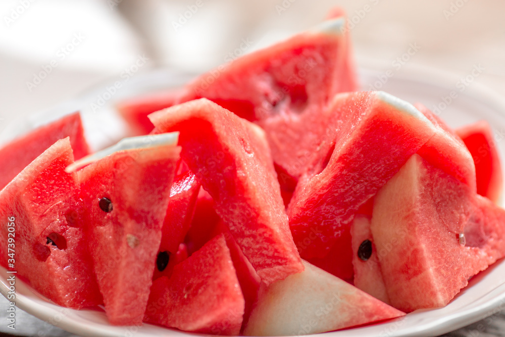 The background of the red flesh watermelon, placed in a ready-to-eat white plate, is a fruit that has a sweet taste and is an alternative health menu. The background of the red flesh watermelon, placed in a ready-to-eat white plate, is a fruit that has a sweet taste and is an alternative health menu.
