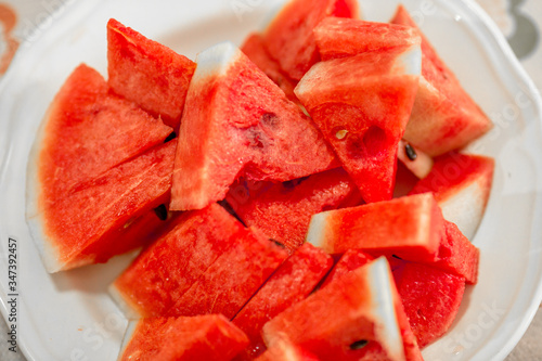 The background of the red flesh watermelon, placed in a ready-to-eat white plate, is a fruit that has a sweet taste and is an alternative health menu.