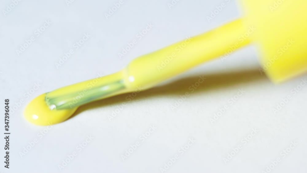Brush with yellow paint on white paper close up Brush with yellow paint on white paper close up