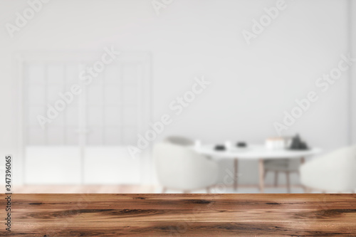 Table in blurry white dining room with door