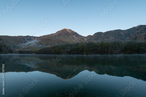 紅葉の上高地・大正池から見た朝日に照らされる焼岳