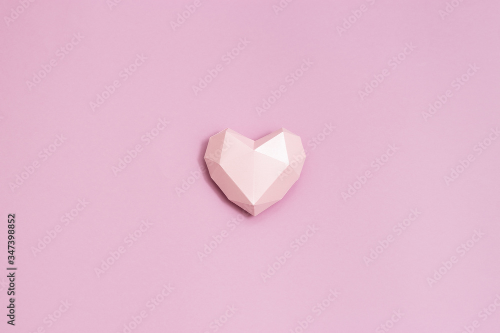 Pink polygonal paper heart shape on pink paper. Holiday background with copy space for Valentines Day. Love concept. Plain colored. Monochrome image. Minimal style. Pink polygonal paper heart shape on pink paper. Holiday background with copy space for Valentines Day. Love concept. Plain colored. Monochrome image. Minimal style.