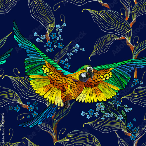 Colorful flying ara parrots  blue flowers and palm leaves seamless pattern. Macaws  jungle birds. Fashionable template for design of clothes  textiles. Paradise forest background