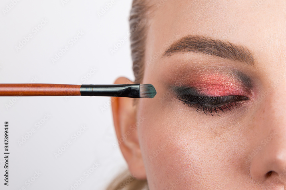 Part of the girl's face with bright eye makeup on a white background, a blank for design.