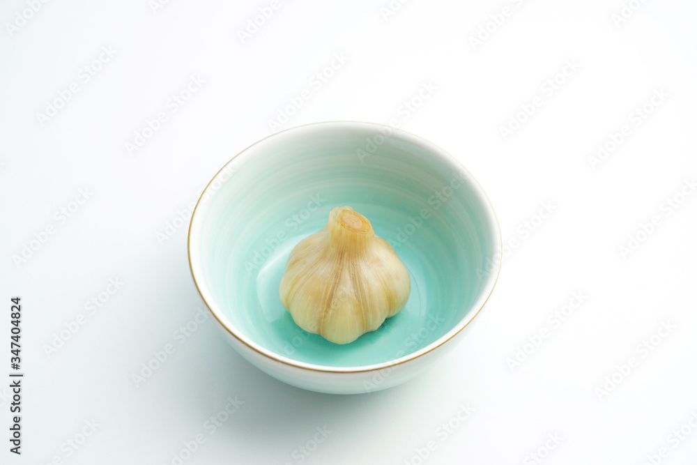Sugar garlic and blue green ceramic bowl on white background Sugar garlic and blue green ceramic bowl on white background